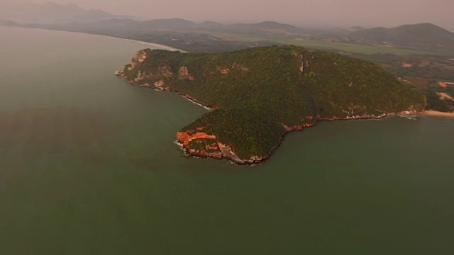 在泰国的Pranburi，日出时，在翠绿色的海洋上，丛林，海滩和山丘上的空中超摄视频素材