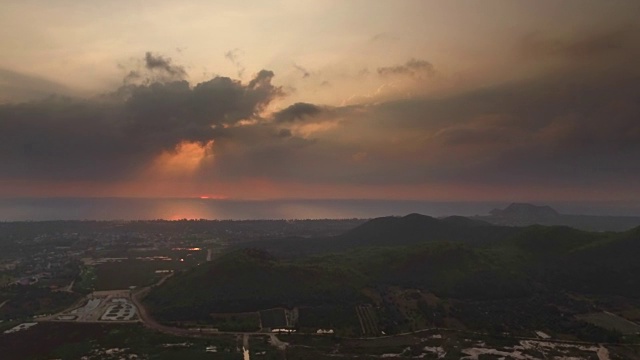 在泰国普兰布里的乡村，金色的阳光在朦胧的日出中穿过云层视频素材