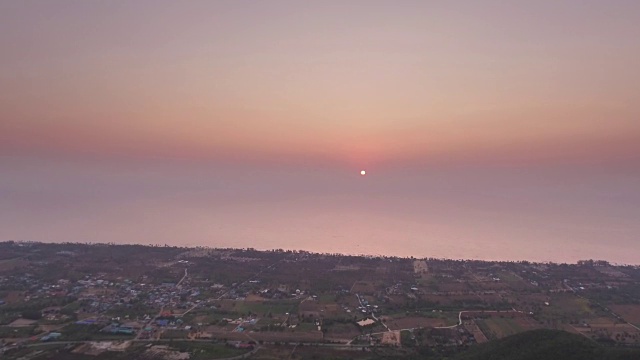 灿烂的太阳从泰国湾的水面升起，乡村景色被强烈的粉红色的日出照亮视频素材