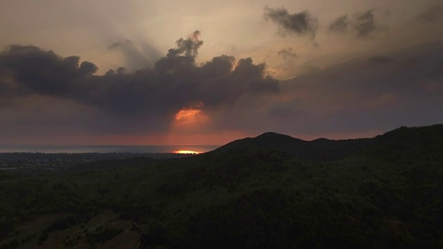 生动的日出与发光的橙色太阳越过山丘和海边村庄周围的Pranburi，泰国视频素材