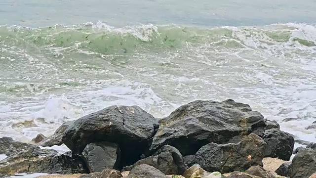 强烈的海浪拍打着布满岩石的海滩视频素材