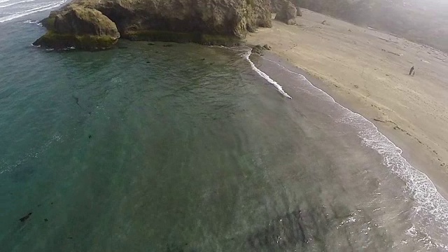 无人机飞行和盘旋在沙滩和海浪视频素材