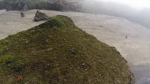 无人机飞越沙滩岩石和海浪视频素材