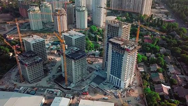 空中无人机拍摄。在大城市的发展中地区建设高层建筑。施工起重机和许多在建房屋视频素材