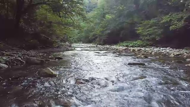 河水在石头上快速流动，无人机从上面射击视频素材