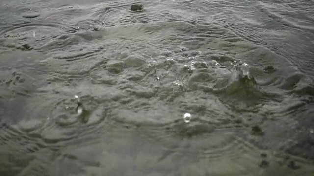 一块石头掉到河里。雨落在山河上。视频素材