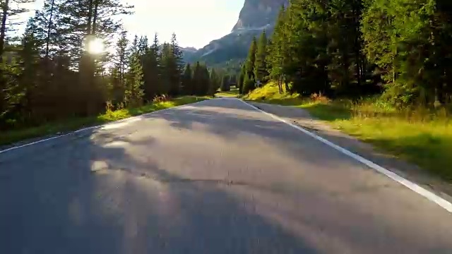 在夕阳西下的森林中行驶在蜿蜒的道路上视频素材