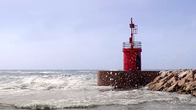 海流击中港口入口的红色灯塔塔。视频素材