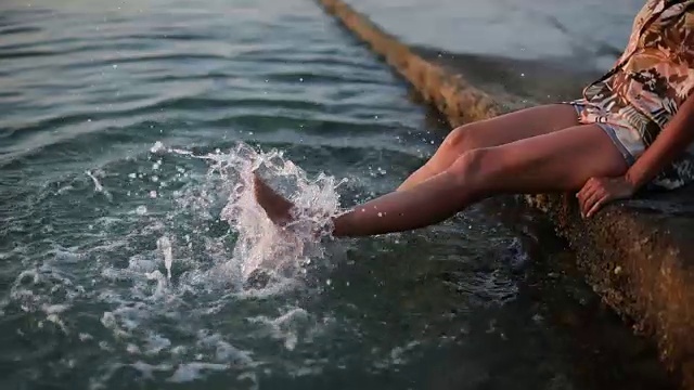 女人的脚在海里溅起水花视频素材