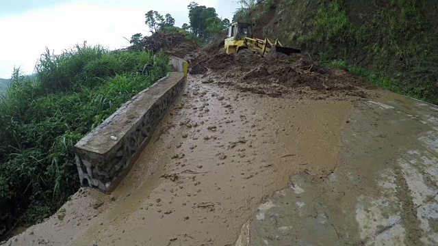 推土机在科迪勒拉悬崖的山路上推着泥石流碎片视频素材