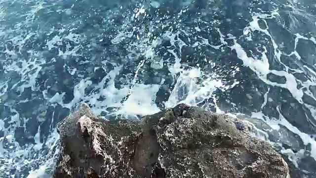 海浪冲击着岩石海岸。蓝色的海洋打破了海浪。视频素材