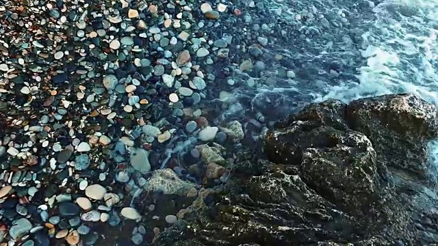 深蓝色的海水拍打着岩石嶙峋的海岸线。近距离观察海浪视频素材