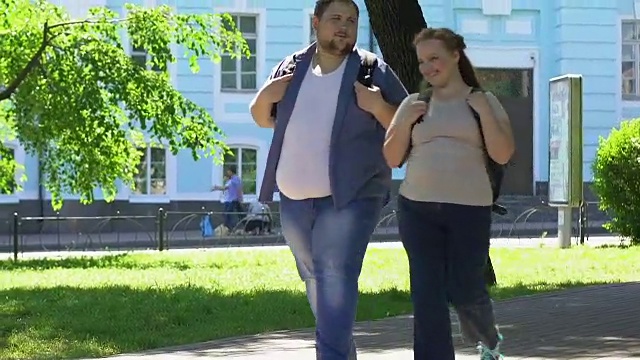 快乐超重的女人和男人在公园散步，浪漫的约会，身体积极视频素材