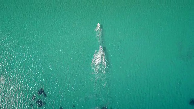 鸟瞰图的一个男人在一个美丽的海滩上玩飞行板在希腊。视频素材