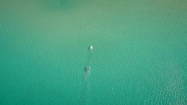 鸟瞰图的一个男人在一个美丽的海滩上玩飞行板在希腊。视频素材