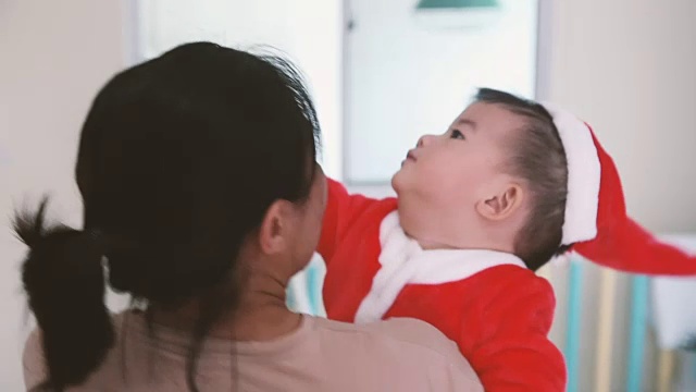 妈妈和宝宝穿着圣诞老人的服装跳舞庆祝圣诞节视频素材