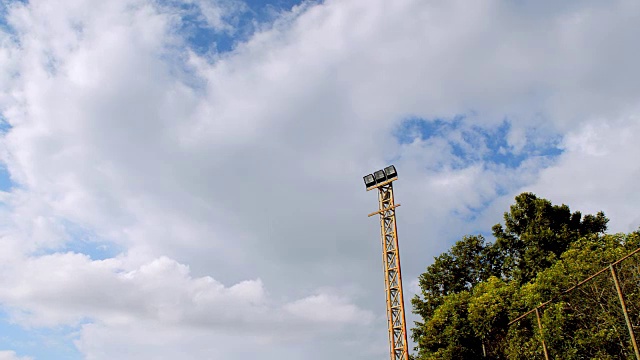 电动聚光灯杆与蓝天背景，时间流逝。视频素材