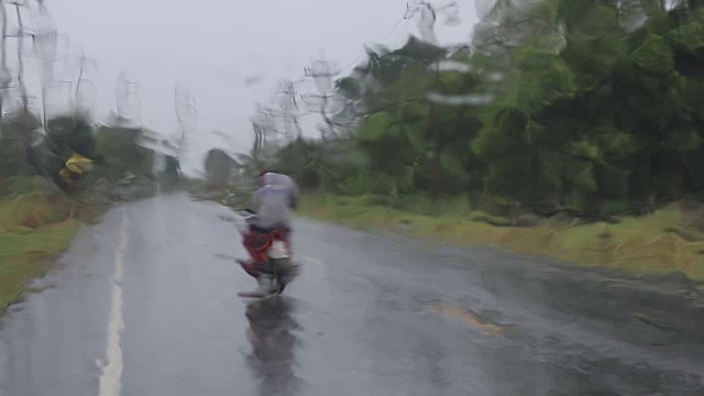 乡村道路上的雨点落在挡风玻璃上。视频素材