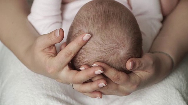 母亲的手抚摸着新生婴儿的头视频素材