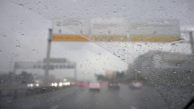 在雨中驾驶汽车在繁忙的高速公路-透过挡风玻璃视频素材