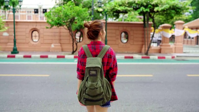 旅行者背包亚洲女人在曼谷旅行，泰国。快乐的年轻女性在惊人的地标假日旅行，享受她的旅程在传统城市。视频素材