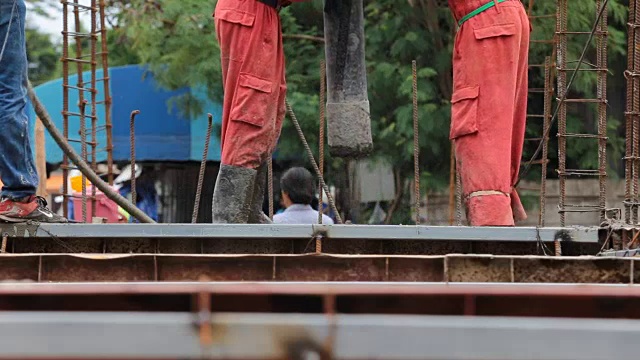 建筑工人控制吊杆混凝土泵建筑。视频素材