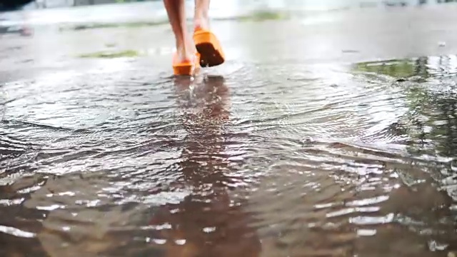 雨后，女孩在街上穿过洪水，慢镜头。视频素材