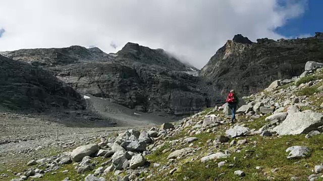 在瑞士恩加丁，一名妇女带着狗在Corvatsch徒步旅行视频下载