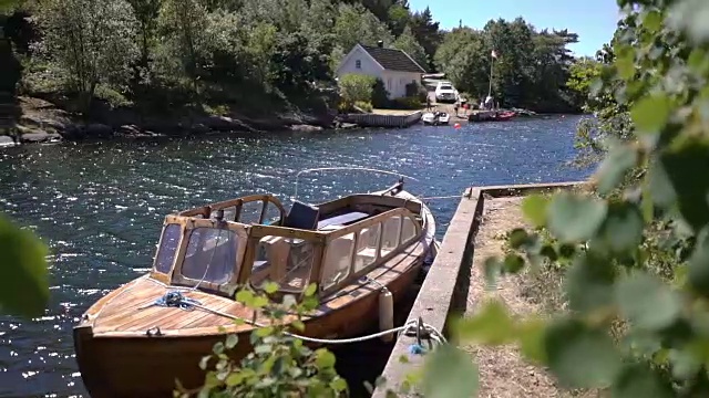 田园田园的斯堪的纳维亚夏季景观。挪威南部海岸上的小屋和小船视频素材