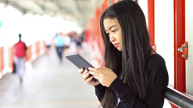 女孩在玩平板电脑笑脸视频素材