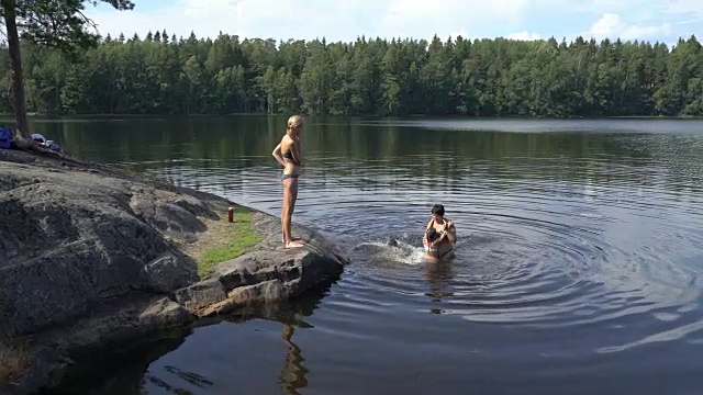 一家人在芬兰的一个森林湖里游泳视频素材