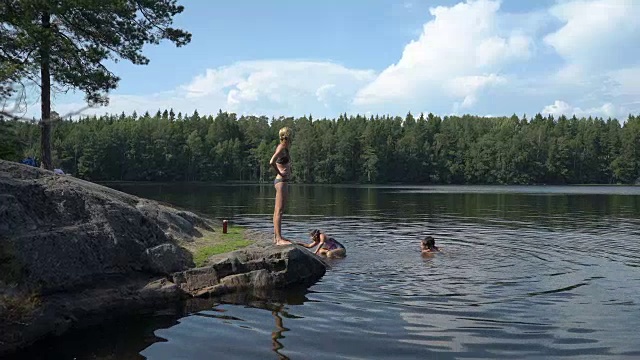 一家人在芬兰的一个森林湖里游泳视频素材