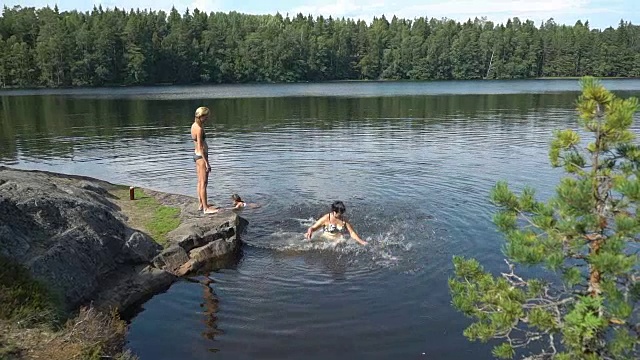 一家人在芬兰的一个森林湖里游泳视频素材