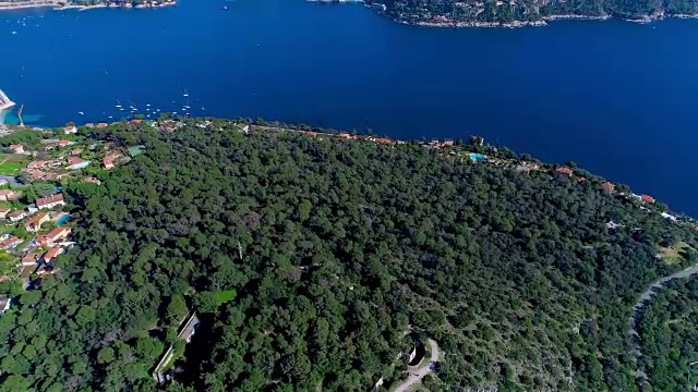 尼斯附近的地中海村庄，在阳光下的绿色山丘上。屋顶和下面狭窄的街道。远处有山有海。法国的夏季，从空中4K无人机拍摄视频素材