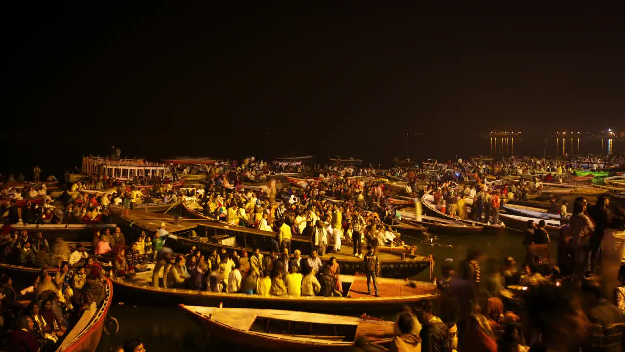 在印度夜间举行的宗教仪式上，人们挤满木船，庆祝大壶节(Kumbh Mela)视频素材