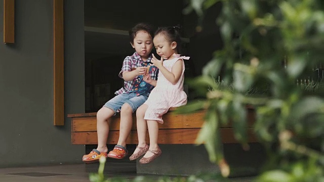 亚洲兄妹正在走廊里吃零食视频素材