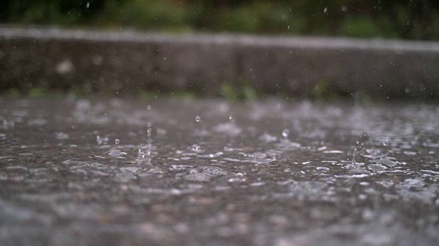 慢镜头，特写:秋天的雨滴落入水坑在街道上视频素材