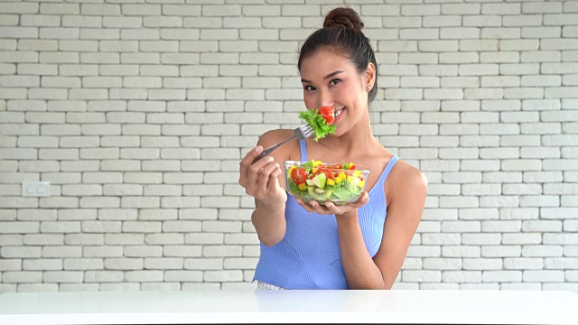 一个年轻漂亮的女人端着一碗沙拉视频素材