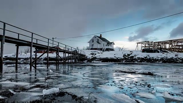 挪威罗浮敦群岛的海岸线上漂浮着破裂的冰和暴风雪中的木屋视频素材