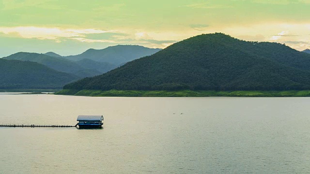 时间流逝筏漂浮在大坝或湖泊和云移动在山上。视频素材