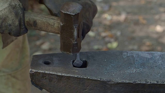 乡村铁匠完成铁钉锻造的慢动作视频素材