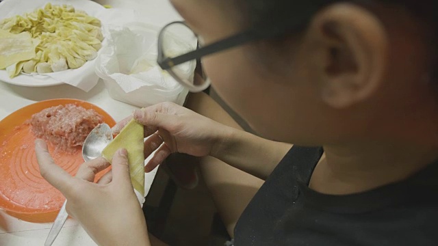 亚洲妇女手工制作馄饨和饺子馅。理念:爱、食物、客人共进晚餐。视频素材