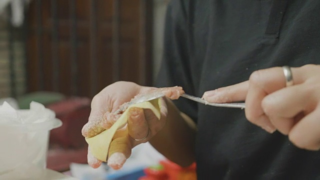 亚洲妇女手工制作馄饨和饺子馅。理念:爱、食物、客人共进晚餐。视频素材