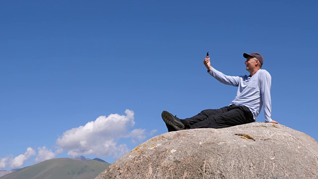 旅行男子在登山时用智能手机拍摄移动视频视频素材