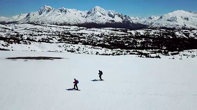 鸟瞰图360左右的两个雪鞋徒步者视频素材