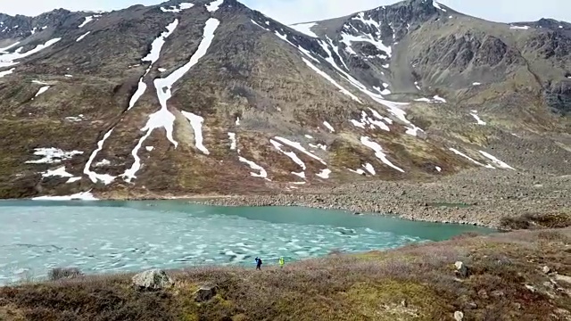 鸟瞰图的徒步旅行者和部分冻结的湖视频素材