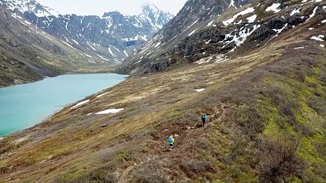 鸟瞰图两个徒步旅行者，一个湖和山视频素材