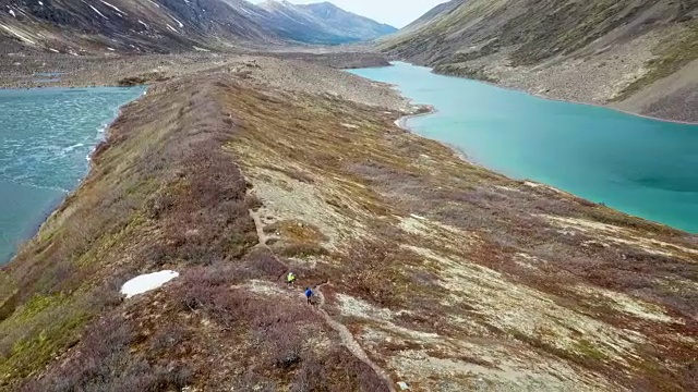 鸟瞰两个湖之间的山脊上的徒步旅行者视频素材