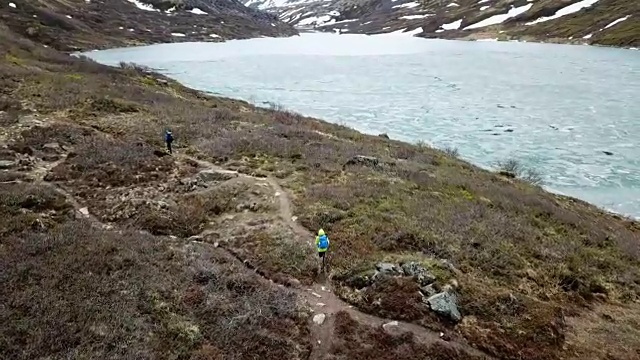 鸟瞰图的徒步旅行者在一个岩石湖海岸小径视频素材