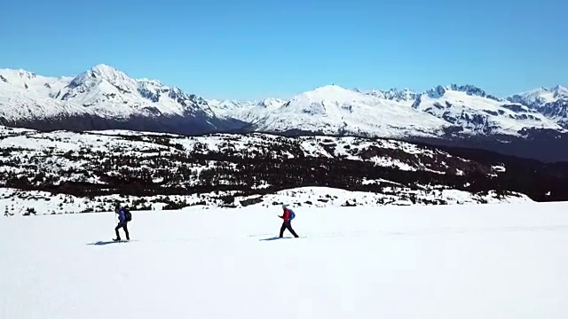 鸟瞰图周围的两个雪鞋徒步旅行者视频素材